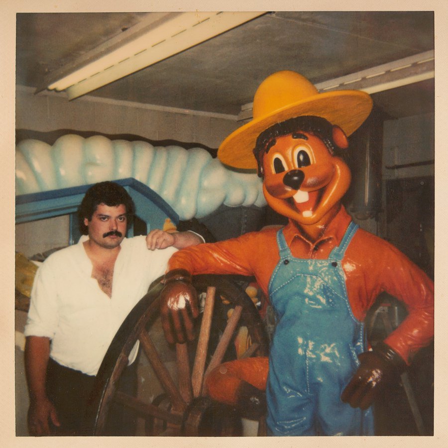 Patrick Soehn stands in his father's workshop in the early 1990s in Kelowna, B.C., next to his look-alike, Clem T. GoFur before installation in Torrington, Alta.