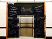 A chalkboard frames the elevator in the repurposed school