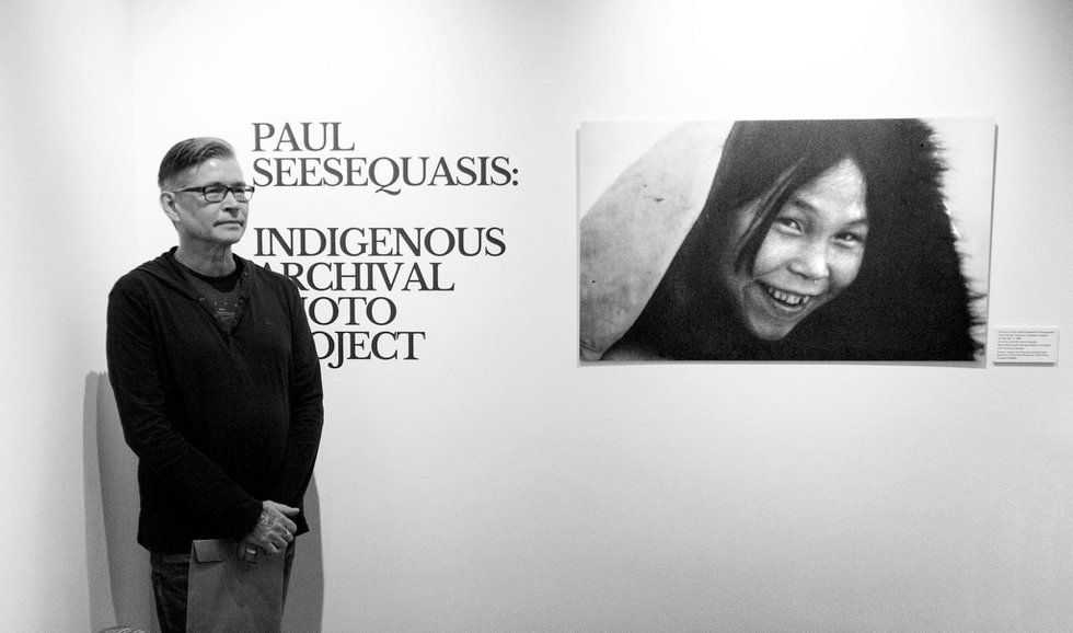 Paul Seesequasis stands with Rosemary Gilliat Eaton’s “Portrait of Inuit artist Napachie Pootoogook, Cape Dorset, Nunavut