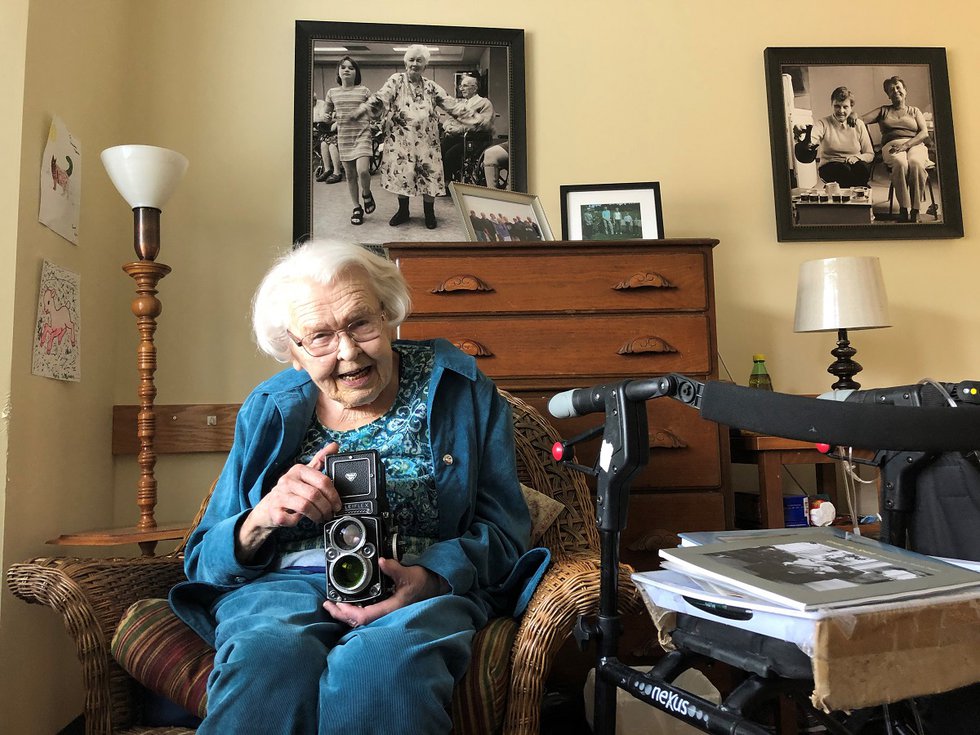 Thelma Pepper poses with a Rolleiflex camera in 2018 at a seniors' home in Saskatoon. (photo by David Gutnick)