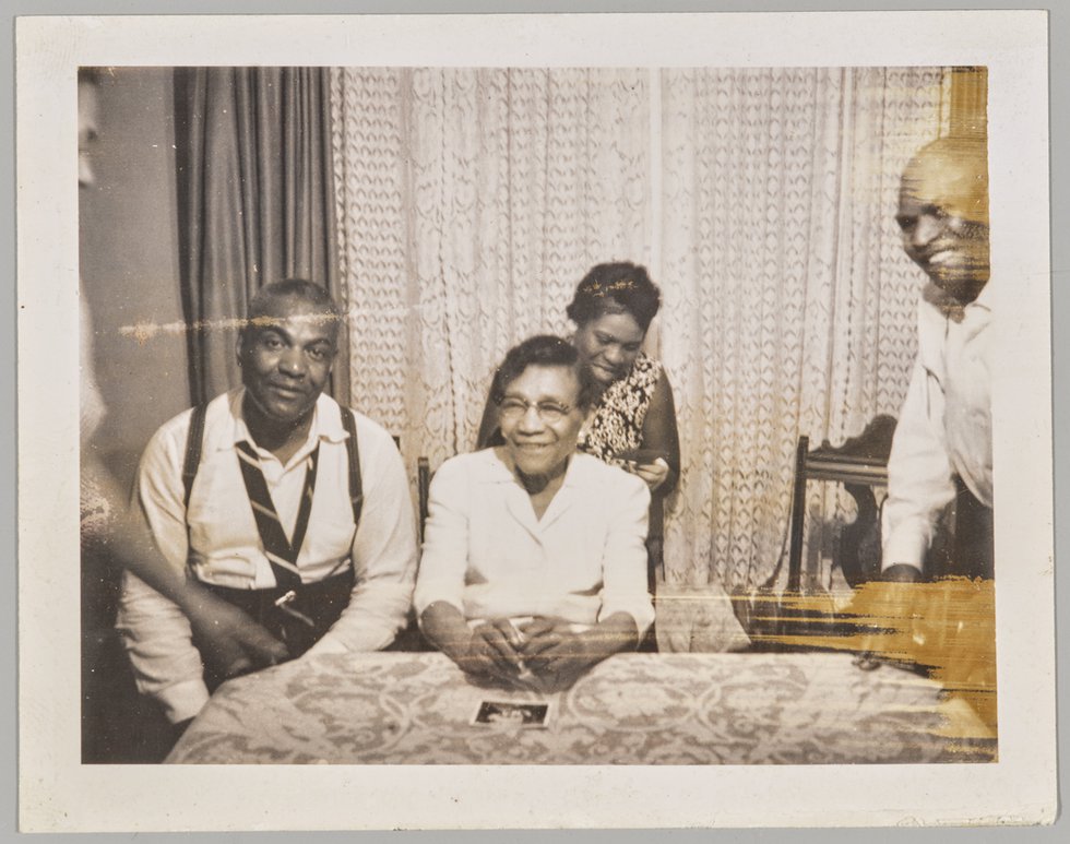 Unknown photographer, “[Group gathered inside looking at Polaroids],” 1963