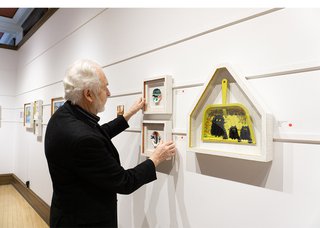 Bill Mayberry adjusts a Maud Lewis artwork at Mayberry Fine Art's downtown Winnipeg location (photo courtesy of Mayberry Fine Art)